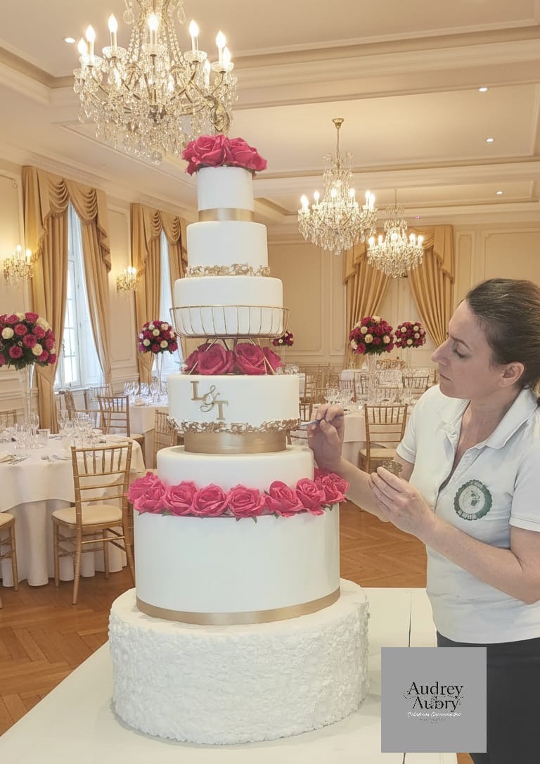 Audrey Aubry montant un wedding cake monumental roses roses dans salle de réception — Audrey Aubry Créations Gourmandes